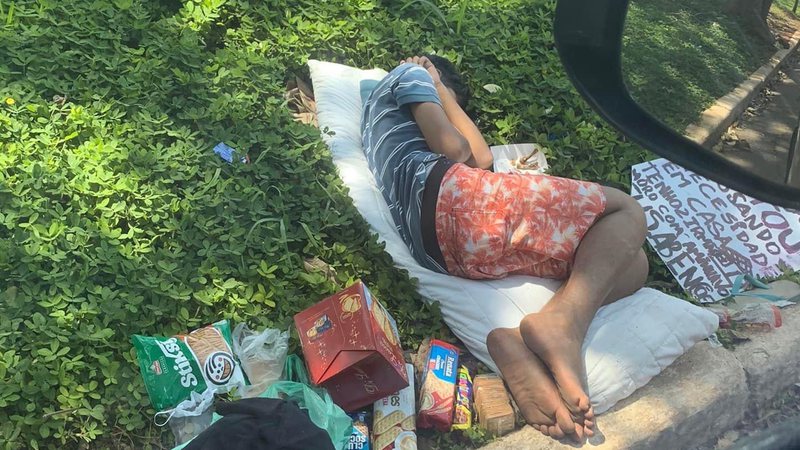 Menino dorme na calçada, em SP,  enquanto descansa do trabalho de vender nos semáforos para conseguir dinheiro para comprar comida - Foto: Mariana Kotscho